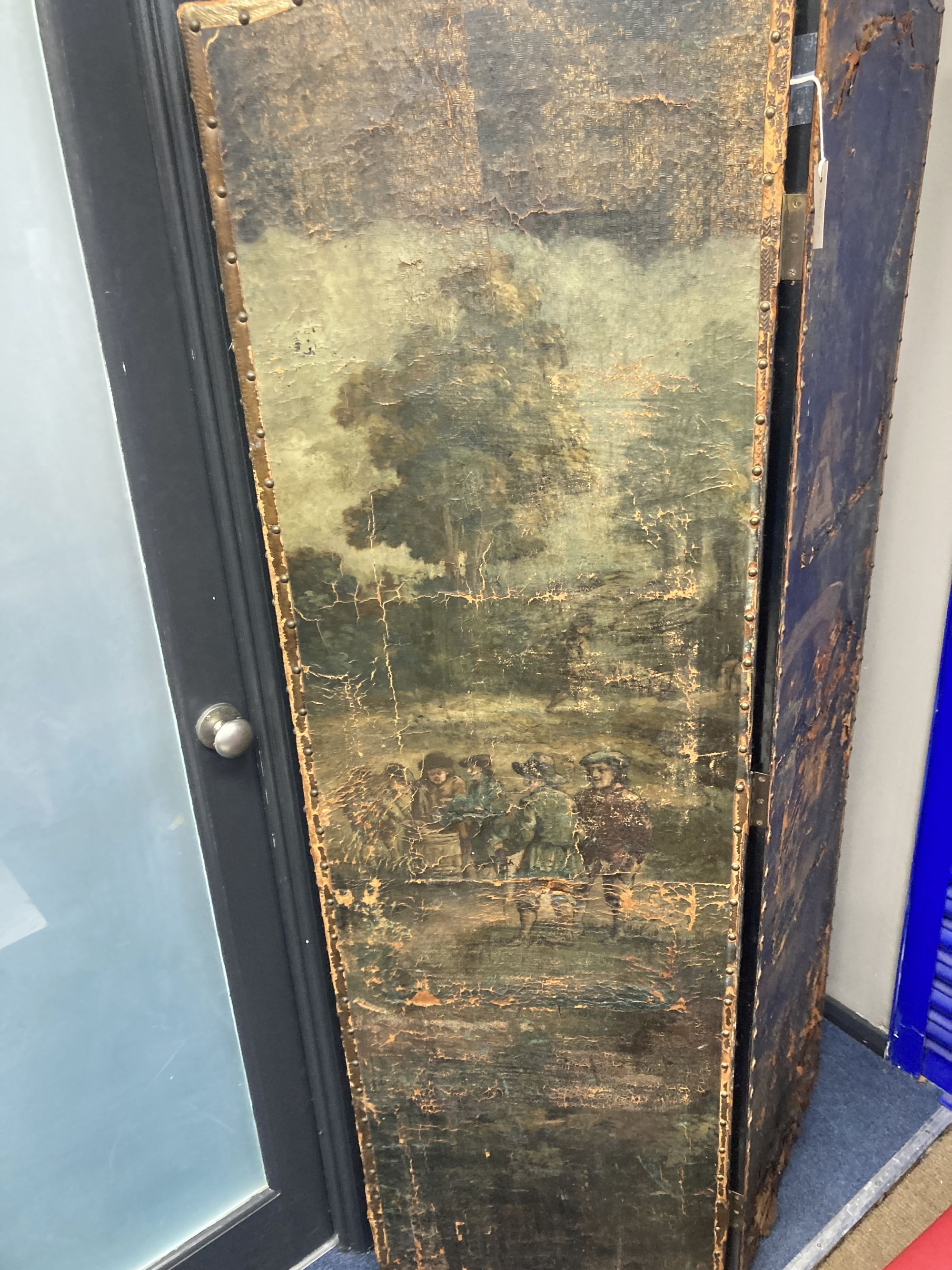A 19th century Spanish four leaf draught screen, painted with a village scene with numerous figures, each panel width 52cm, height 184c